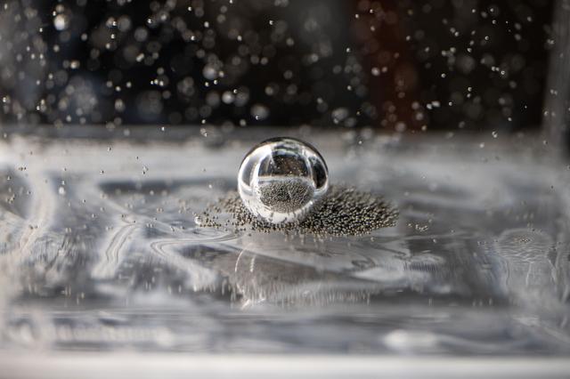 NASA image: Tiny ball bearings surround a larger central bearing during the Fluid Particles experiment