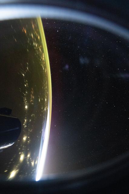 NASA image: The city lights of Central Asia sparkle underneath a bright yellow airglow