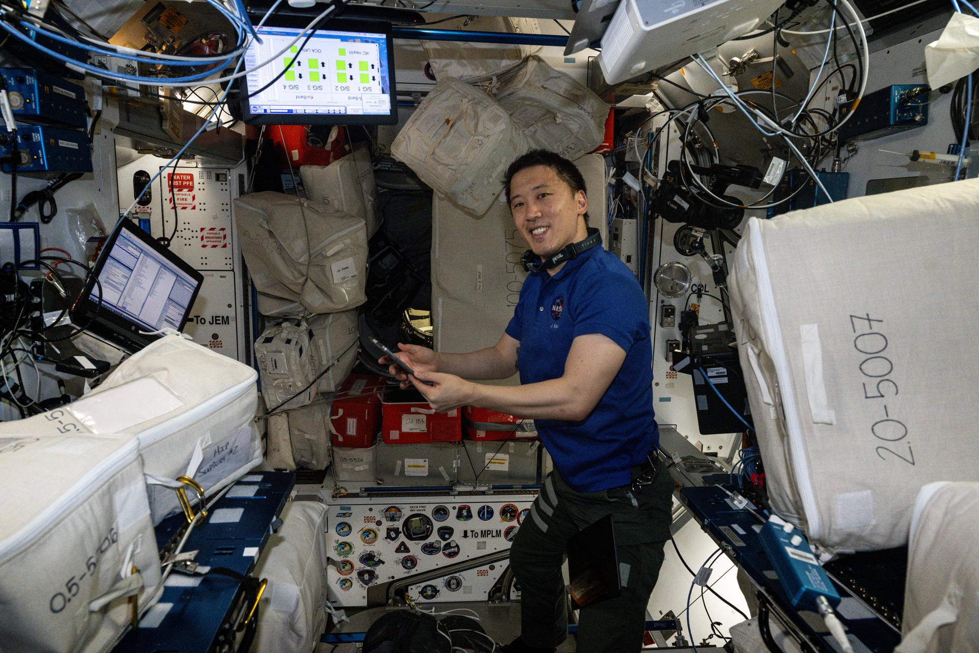 NASA astronaut and Expedition 73 Flight Engineer Jonny Kim smiles for a portrait whle organizing cargo inside the International Space Station's Harmony module.