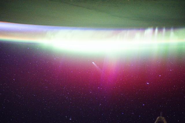 NASA image: A bright, neon-like aurora radiates above Earth and seemingly absorbs Comet Lemmon 