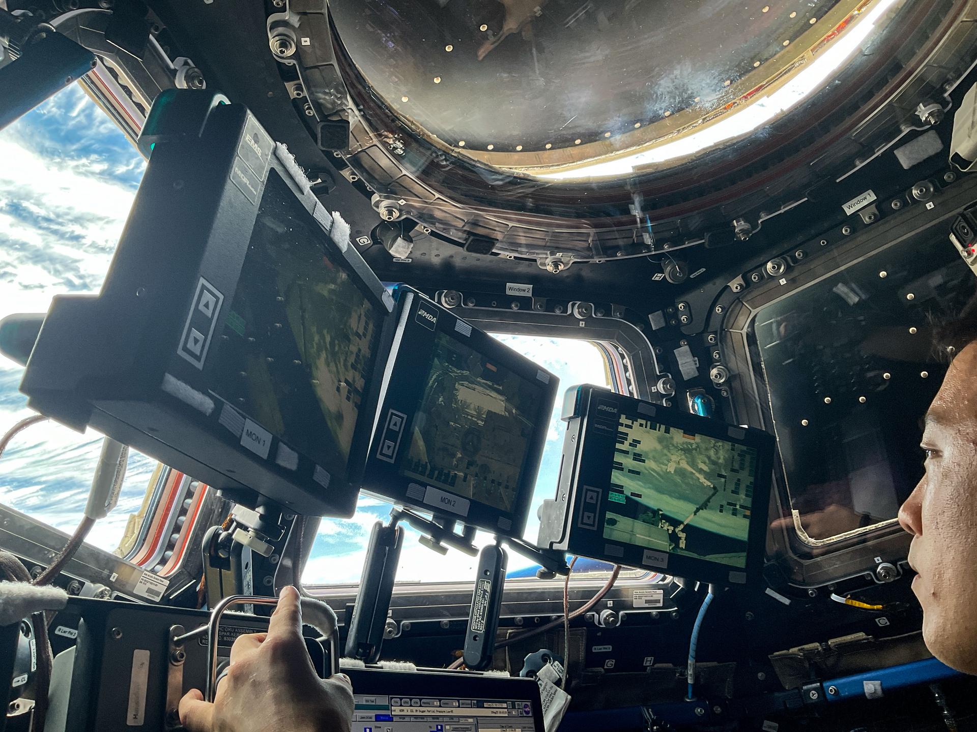 NASA astronaut and Expedition 73 Flight Engineer Jonny Kim practices Canadarm2 robotic maneuvers at the robotics workstation inside the International Space Station's cupola. Kim was preparing for the robotic capture of the Northrop Grumman Cygnus XL cargo spacecraft that launched on Sept. 14, 2025, and arrived on Sept. 18 delivering about 11,000 pounds of science, supplies, and hardware to the Expedition 73 crew.