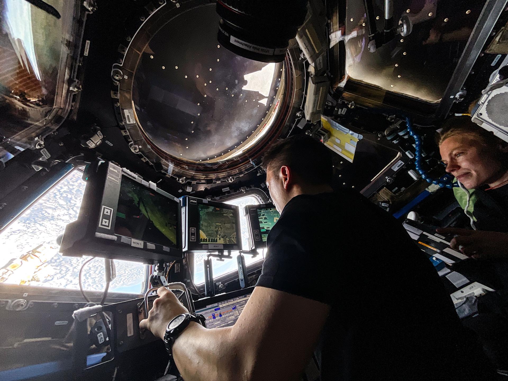 iss073e0981653 (Sept. 11, 2025) --- Expedition 73 Flight Engineers Jonny Kim and Zena Cardman, both NASA astronauts, practice Canadarm2 robotic maneuvers at the robotics workstation inside the International Space Station's cupola. The duo was preparing for the robotic capture of the Northrop Grumman Cygnus XL cargo spacecraft that launched on Sept. 14, 2025, and arrived on Sept. 18 delivering about 11,000 pounds of science, supplies, and hardware to the Expedition 73 crew.