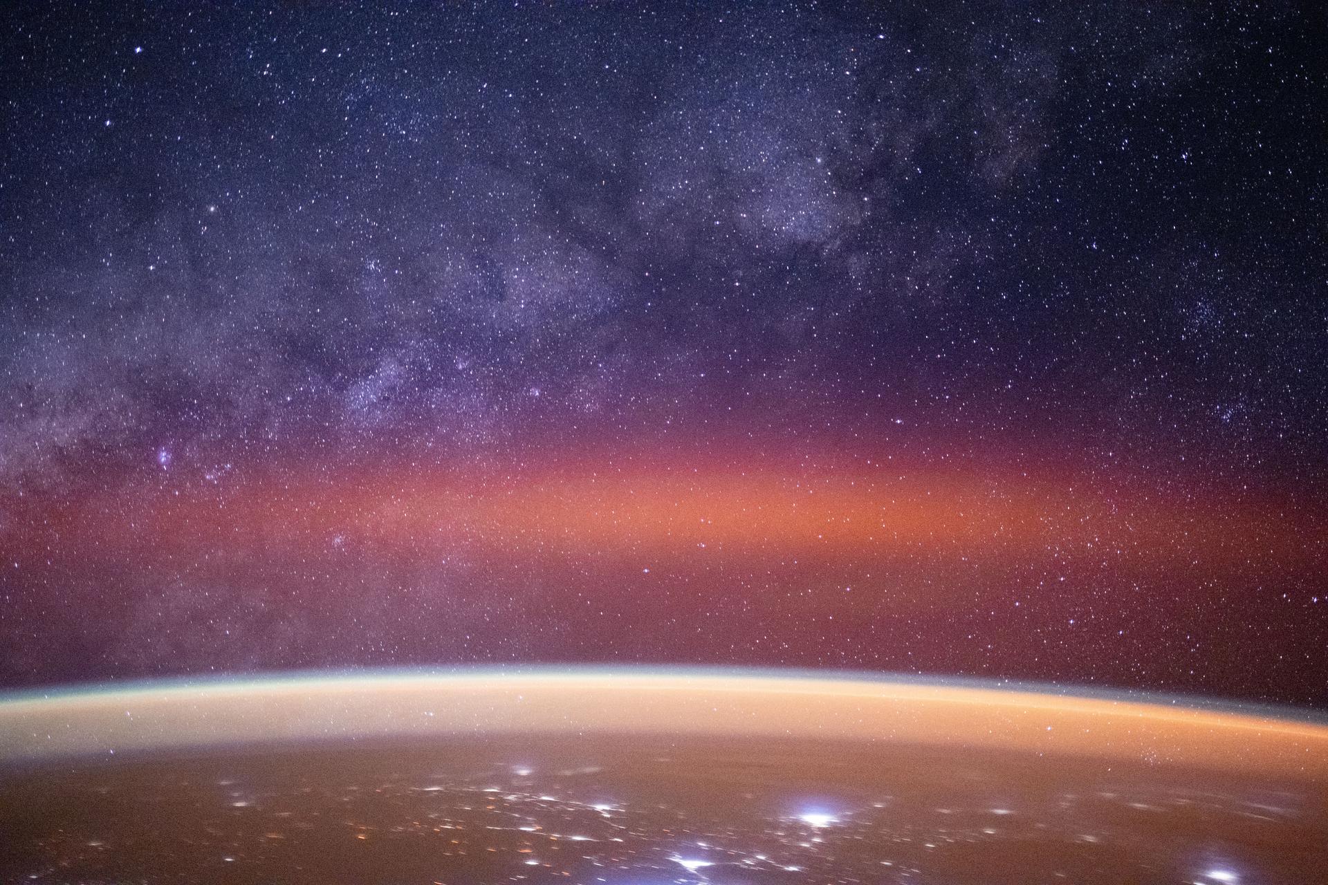 The Milky Way spans the night sky above a bright orange-yellow airglow that blankets the city lights along the east coast of Africa, from Kenya to Somalia. The International Space Station was orbiting 259 miles above the Indian Ocean, north of Madagascar, at approximately 10:29 p.m. local time when this photograph was taken.