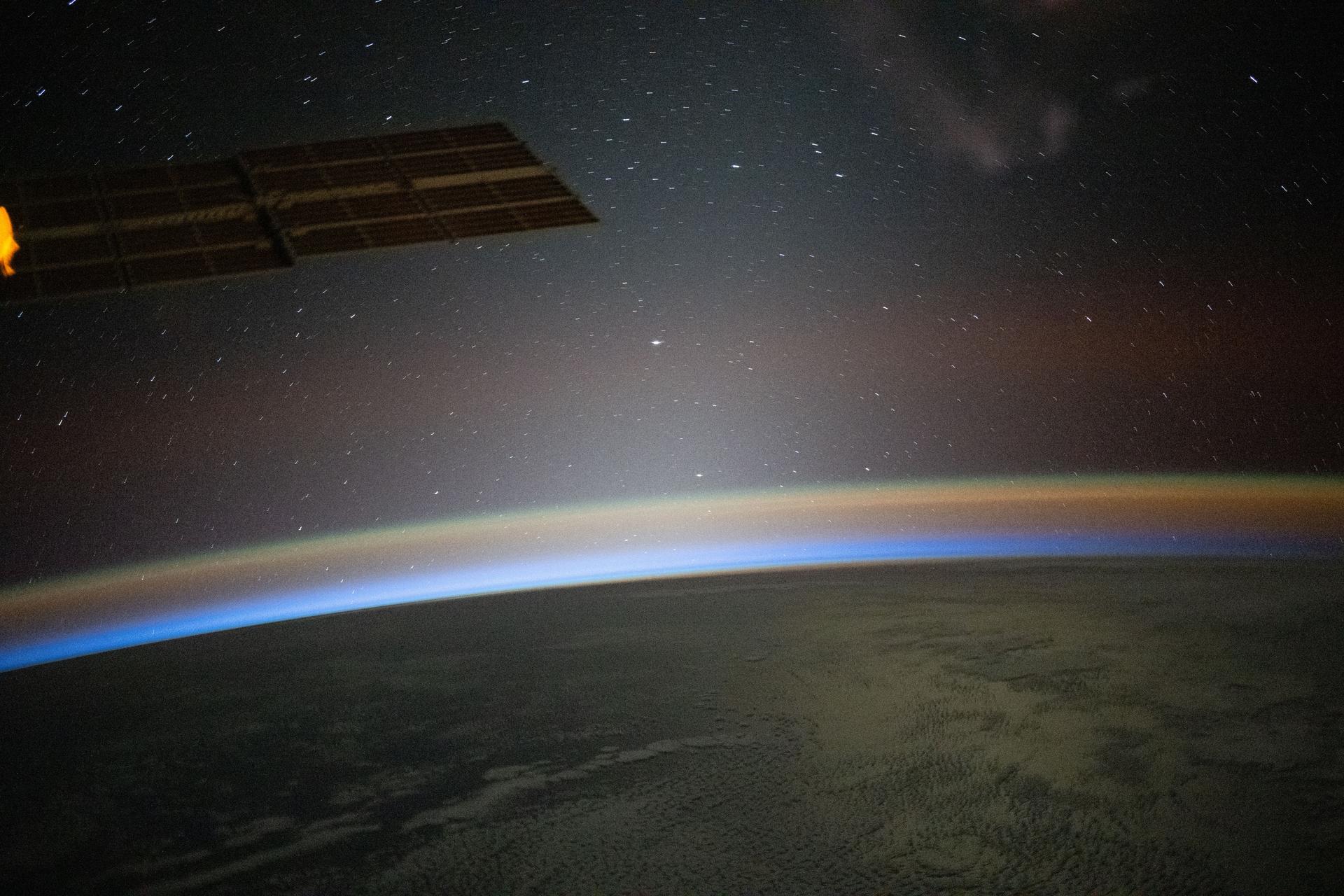 A red-yellow airglow blankets Earth as the last rays of an orbital sunset illuminate the atmosphere in this photograph from the International Space Station as it orbited 262 miles above the South Atlantic Ocean.