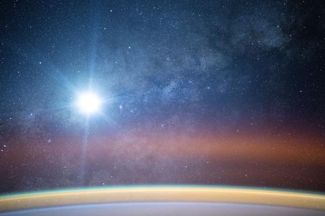 NASA image: A bright airglow blankets Earth's horizon as the Milky Way illuminates the night sky