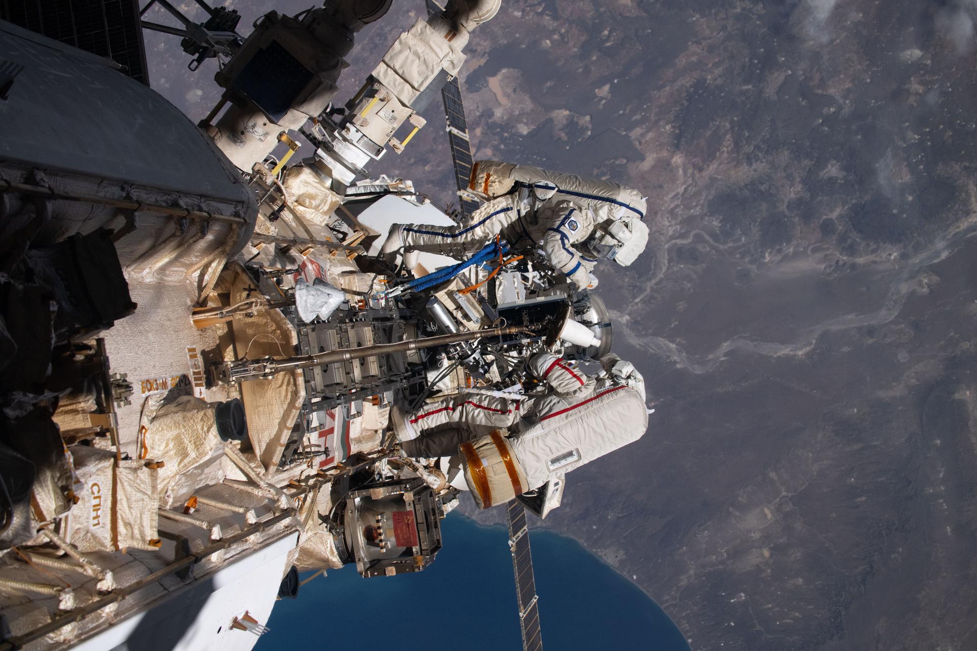 iss073e0988203 (Oct. 28, 2025) --- Roscosmos cosmonauts (top to bottom) Alexey Zubritsky and Sergey Ryzhikov are pictured in their Orlan spacesuits conducting a spacewalk 270 miles above southern Argentina. During the spacewalk, the duo installed a pulse plasma injector, cleaned a window on the Nauka science module, replaced a materials science cassette on Nauka, and moved a controller interface for the European robotic arm.