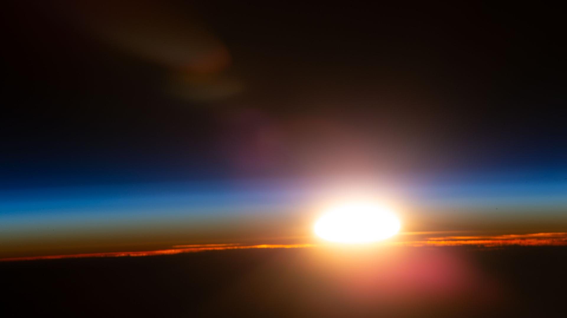 An orbital sunrise illuminates Earth's atmosphere and cloud tops in this photograph captured from the International Space Station as it orbited 264 miles above the Czech Republic in Eastern Europe.