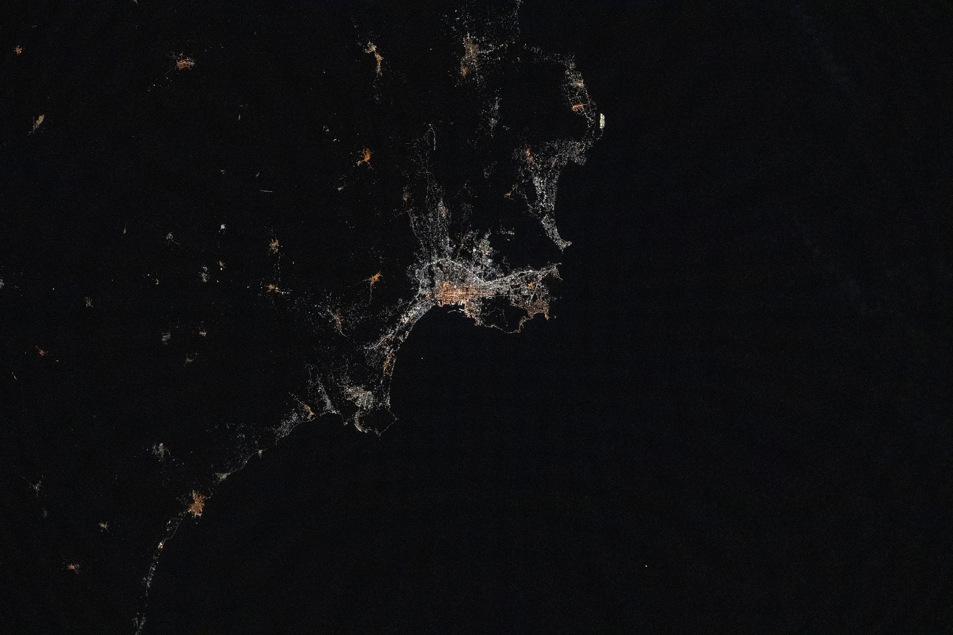iss073e1047080 (Nov. 2, 2025) --- Palermo, Italy—a 2,700-year-old city on the Sicilian coast of the Tyrrhenian Sea—is pictured at approximately 10:12 p.m. local time from the International Space Station as it orbited 260 miles above the Mediterranean Sea. The city’s lights reveal a transition from older, amber-hued sodium-vapor lamps in the historic center to cooler, white LED lighting in the surrounding suburbs.