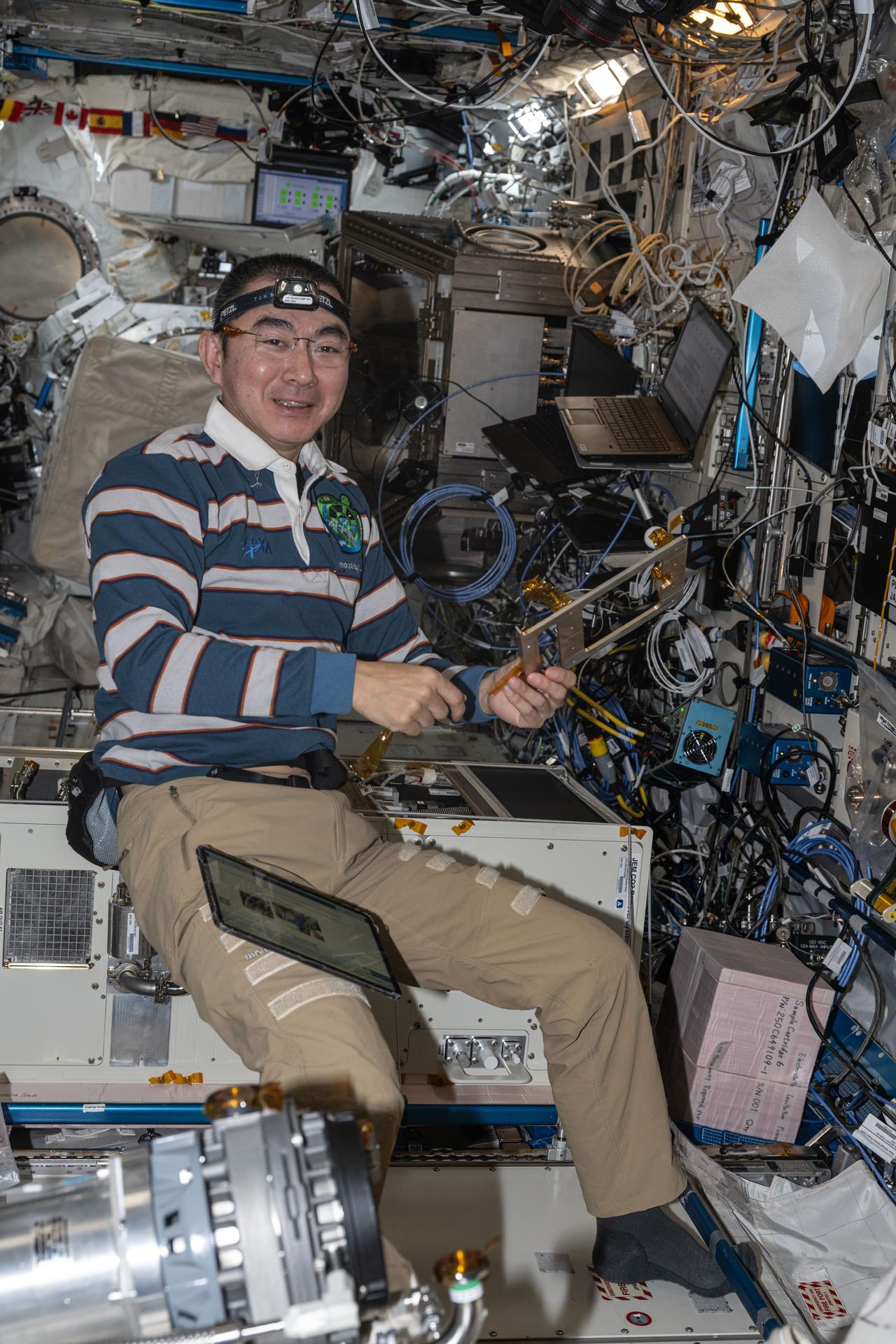 JAXA (Japan Aerospace Exploration Agency) astronaut and Expedition 73 Flight Engineer Kimiya Yui assembles and installs carbon dioxide removal gear inside the International Space Station's Kibo laboratory module.