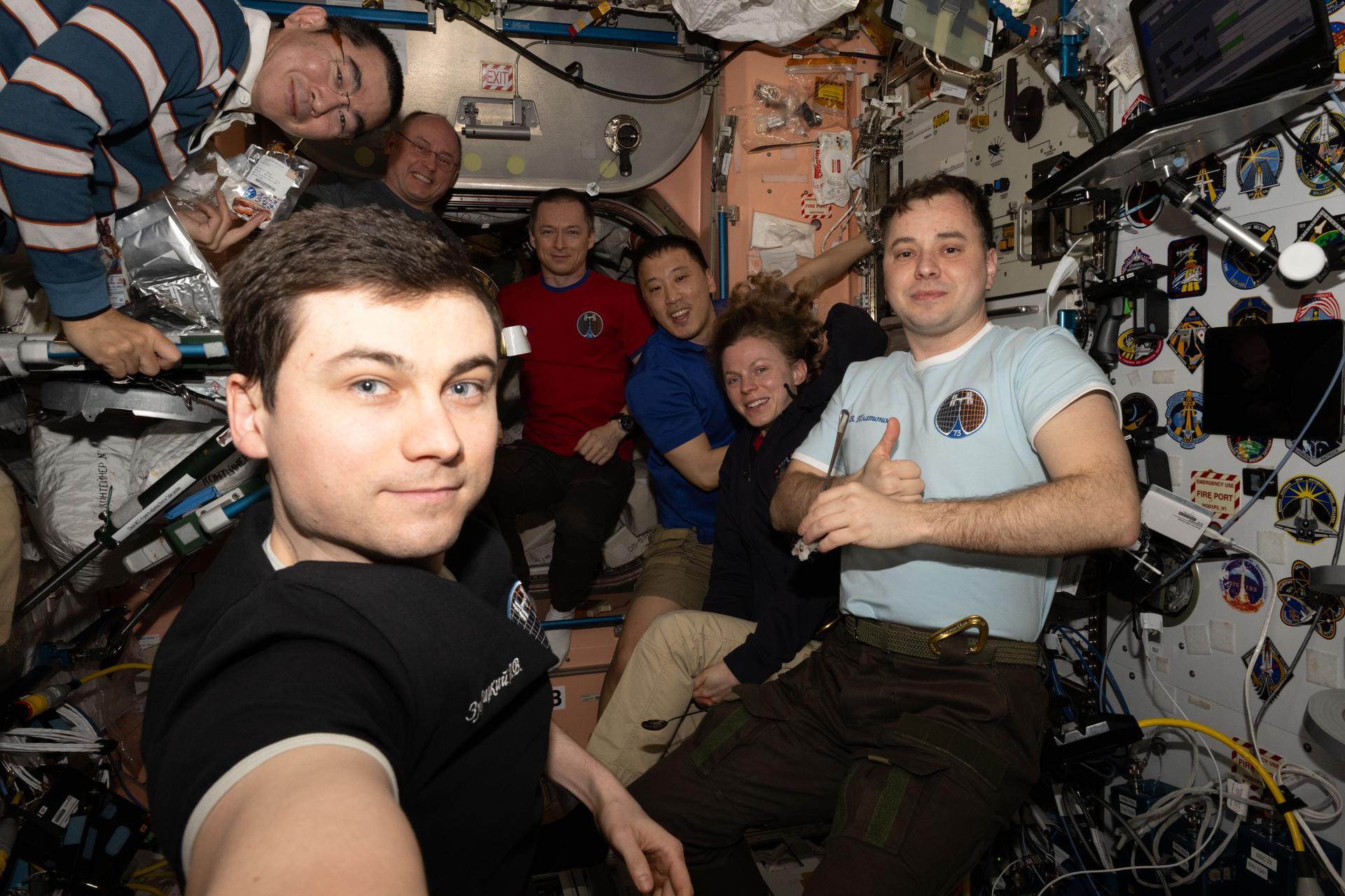 All seven members of the Expedition 73 crew gather for a portrait during dinnertime at the galley inside the International Space Station’s Unity module. In the foreground, holding the camera for a group selfie, is Roscosmos cosmonaut Alexey Zubritsky. In the back, from left, are JAXA (Japan Aerospace Exploration Agency) astronaut Kimiya Yui, NASA astronaut Mike Fincke, Roscosmos cosmonaut and station commander Sergey Ryzhikov, NASA astronauts Jonny Kim and Zena Cardman, and Roscosmos cosmonaut Oleg Platonov.