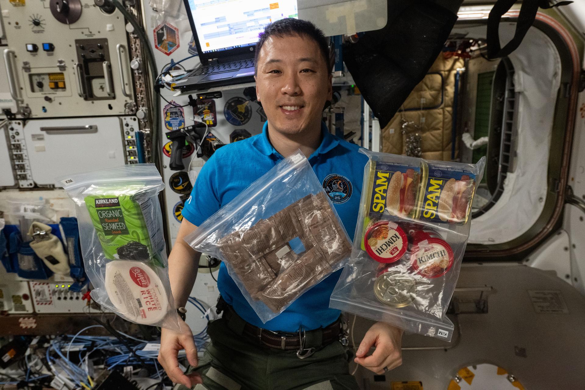 iss073e1068412 (Nov. 4, 2025) --- NASA astronaut and Expedition 73 Flight Engineer Jonny Kim shows off a variety of food items from South Korea and the U.S. during lunchtime aboard the International Space Station's Unity module.