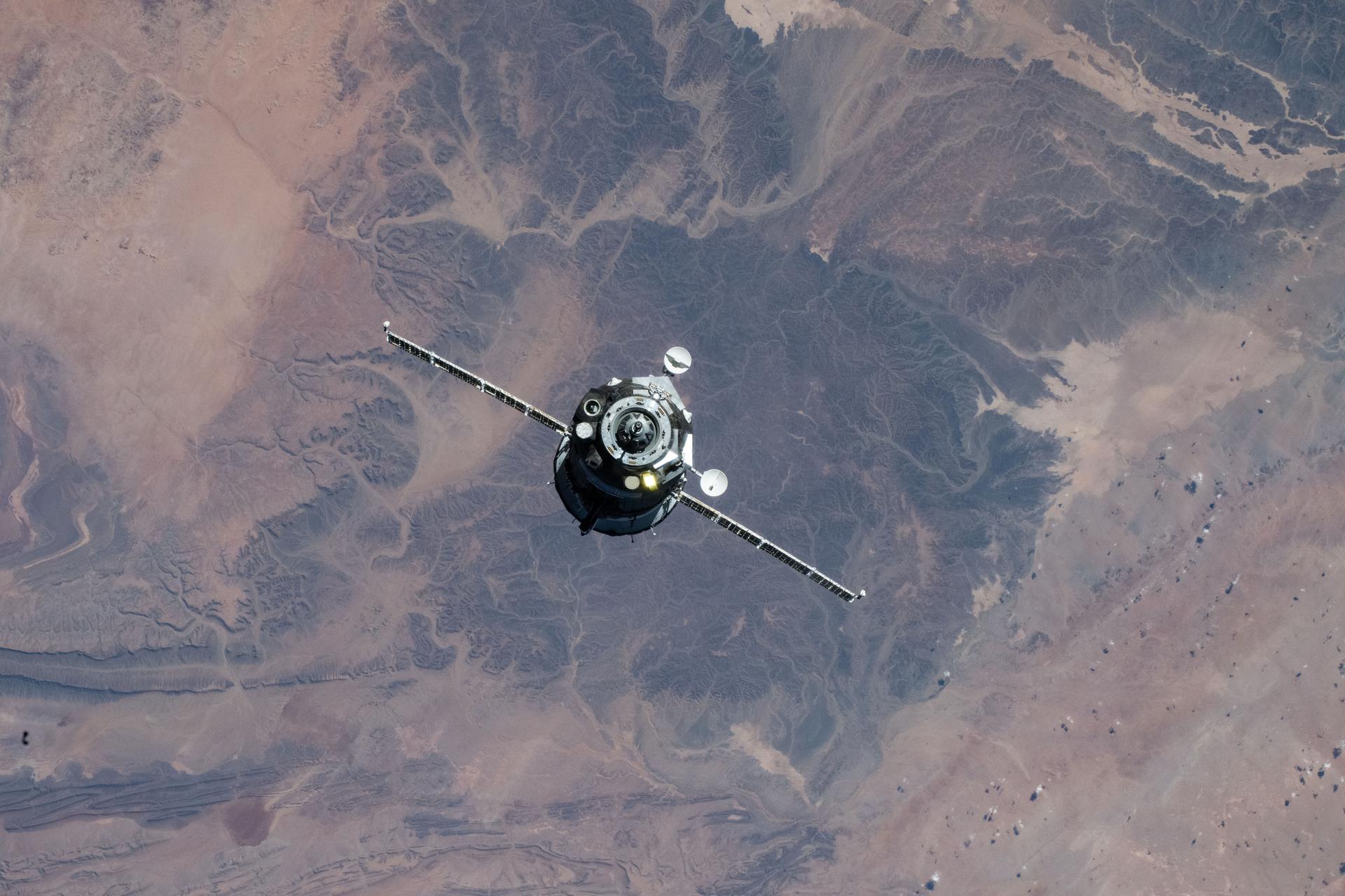 iss073e1196741 (Nov. 27, 2025) --- The Soyuz MS-28 crew spacecraft carrying NASA astronaut Chris WIlliams and Roscosmos cosmonauts Sergey Kud-Sverchkov and Sergei Mikaev approaches the International Space Station. Both spacecraft were orbiting 263 miles above the mountainous region in southern Morocco at the time of this photograph.