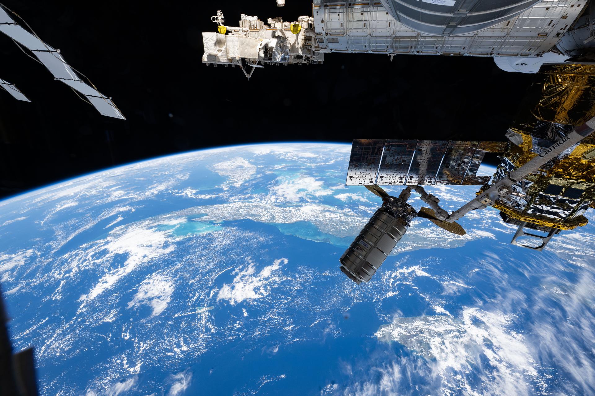 Northrop Grumman's Cygnus XL cargo craft is pictured in the grips of the International Space Station Canadarm2 robotic arm. Cygnus XL had been temporarily released from its Earth-facing port on the Unity module to make room for the Soyuz MS-28 crew spacecraft, which was scheduled to arrive the next day and dock to the Rassvet module. JAXA's (Japan Aerospace Exploration Agency) HTV-X1 cargo craft, with its solar arrays deployed, is seen berthed to the Earth-facing port of the Harmony module. The orbital outpost was soaring 262 miles above the Caribbean Sea south of Cuba at the time of this photograph.
