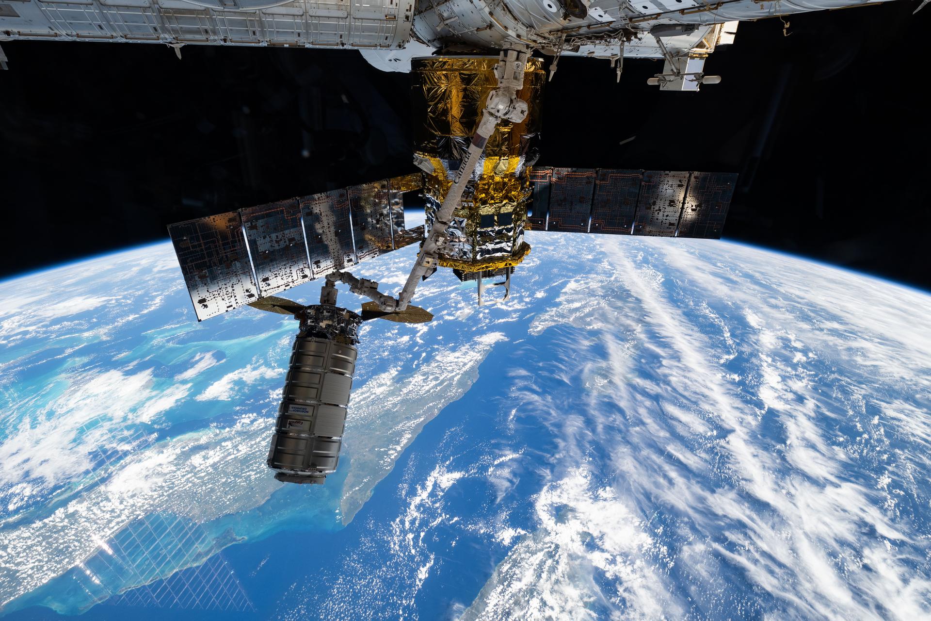 Northrop Grumman's Cygnus XL cargo craft is pictured in the grips of the International Space Station Canadarm2 robotic arm. Cygnus XL had been temporarily released from its Earth-facing port on the Unity module to make room for the Soyuz MS-28 crew spacecraft, which was scheduled to arrive the next day and dock to the Rassvet module. JAXA's (Japan Aerospace Exploration Agency) HTV-X1 cargo craft, with its solar arrays deployed, is seen berthed to the Earth-facing port of the Harmony module. The orbital outpost was soaring 261 miles above the Caribbean Sea south of Cuba at the time of this photograph.