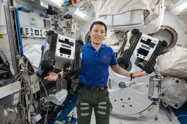 NASA image: NASA astronaut Jonny Kim displays a pair of Astrobee free-flying robotic assistants
