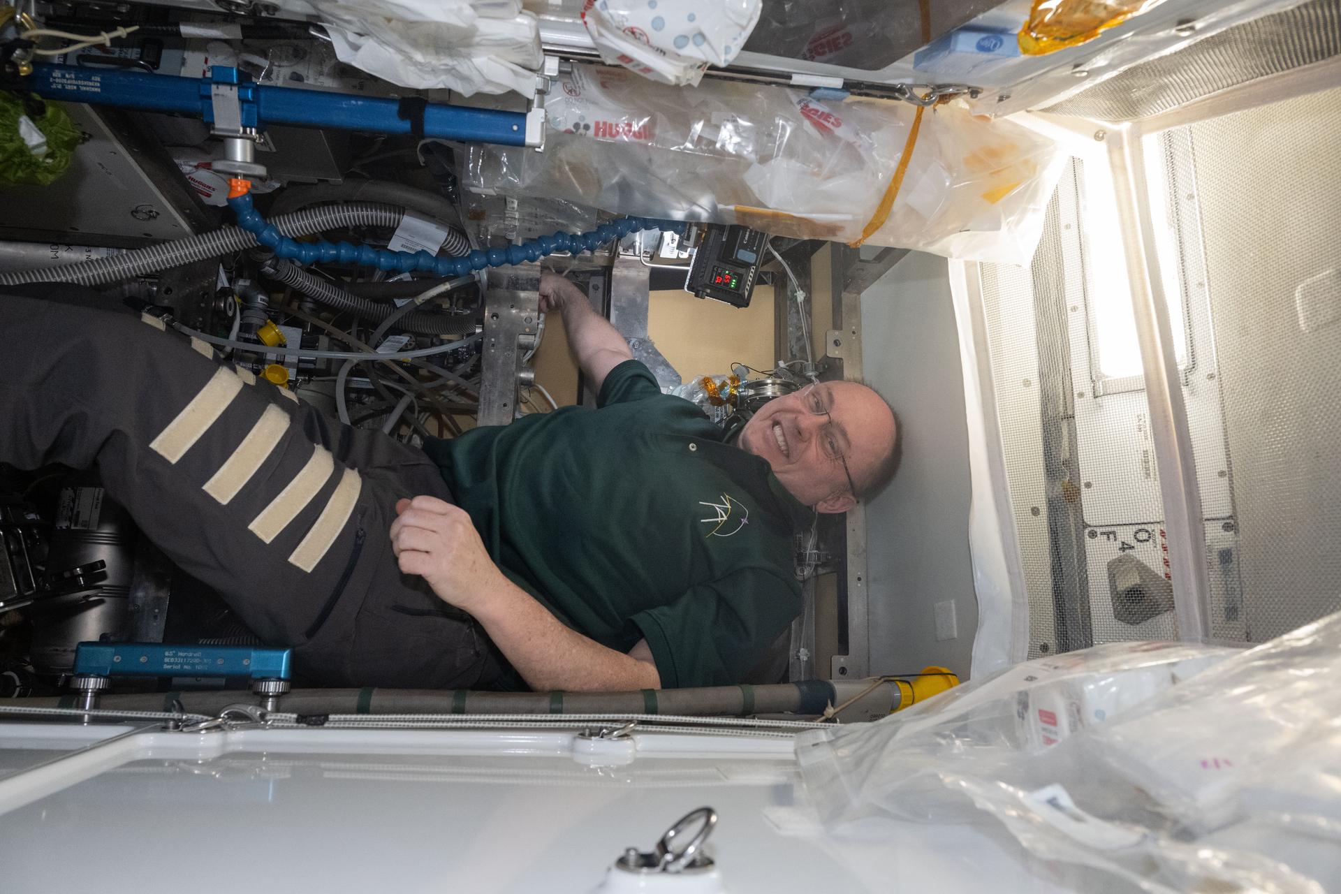 NASA astronaut and Expedition 74 Commander Mike Fincke works inside the Tranquility module replacing orbital plumbing components on the waste and hygiene compartment, the International Space Station’s restroom.