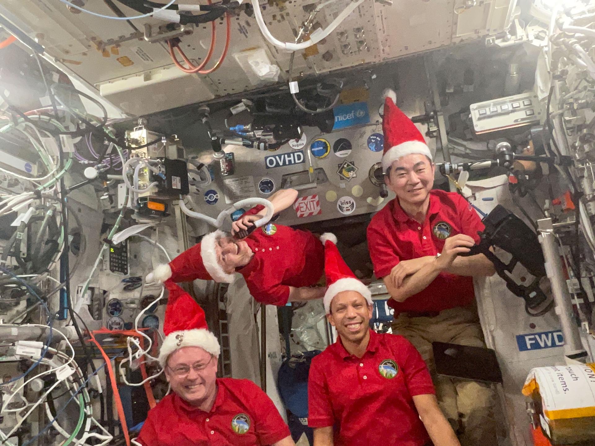 Four Expedition 74 astronauts pose for a festive portrait celebrating the holiday season aboard the International Space Station. Clockwise from bottom left are, station Commander Mike Fincke of NASA and Flight Engineers Zena Cardman of NASA, Kimiya Yui of JAXA (Japan Aerospace Exploration Agency), and Chris Williams of NASA.