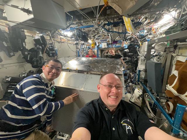 NASA image: Four Expedition 74 crew members move heavy science hardware