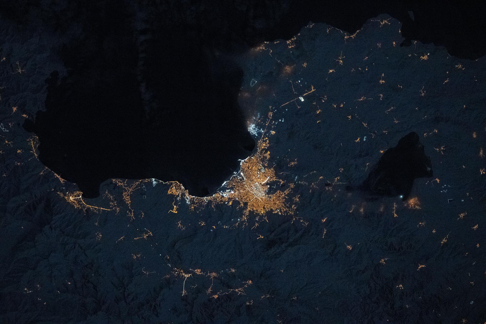 The amber high-pressure sodium lights of Van, Türkiye (center), along with its suburbs and villages, dot the southeast coast of Lake Van in the nation’s Eastern Anatolia Region. The International Space Station was orbiting 262 miles above Earth at approximately 10:12 p.m. local time when this photograph was taken.