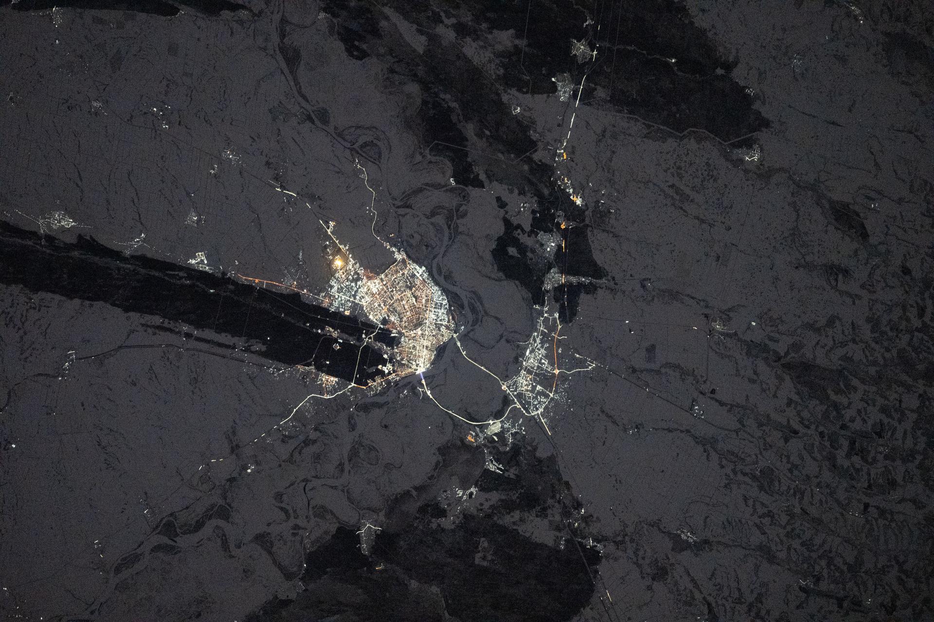 The city lights of Barnaul in Siberia, Russia, contrast with the extreme winter landscape. The darkened strip of land jutting out from the center of the city is part of the Ob River floodplain and terrace system, which is ideal for farming crops like wheat, barley, and sunflowers. The International Space Station was orbiting 265 miles above Earth at approximately 1:20 a.m. local time when this photograph was taken.