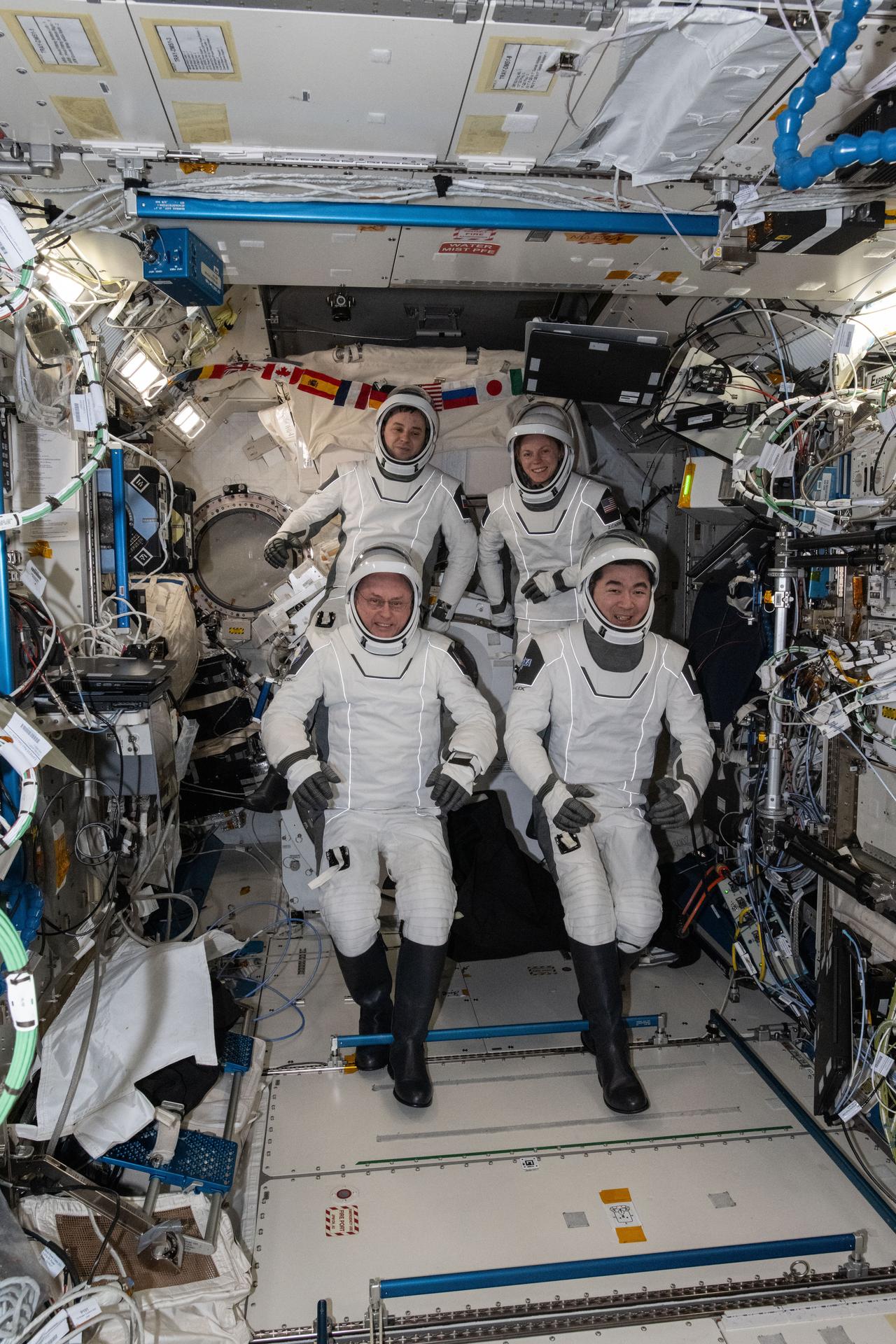 Four SpaceX Crew-11 members gather together for a crew portrait wearing their Dragon pressure suits during a suit verification check inside the International Space Station's Kibo laboratory module. Clockwise from bottom left are, NASA astronaut Mike Fincke, Roscosmos cosmonaut Oleg Platonov, NASA astronaut Zena Cardman, and JAXA (Japan Aerospace Exploration Agency) astronaut Kimiya Yui. Credit: NASA