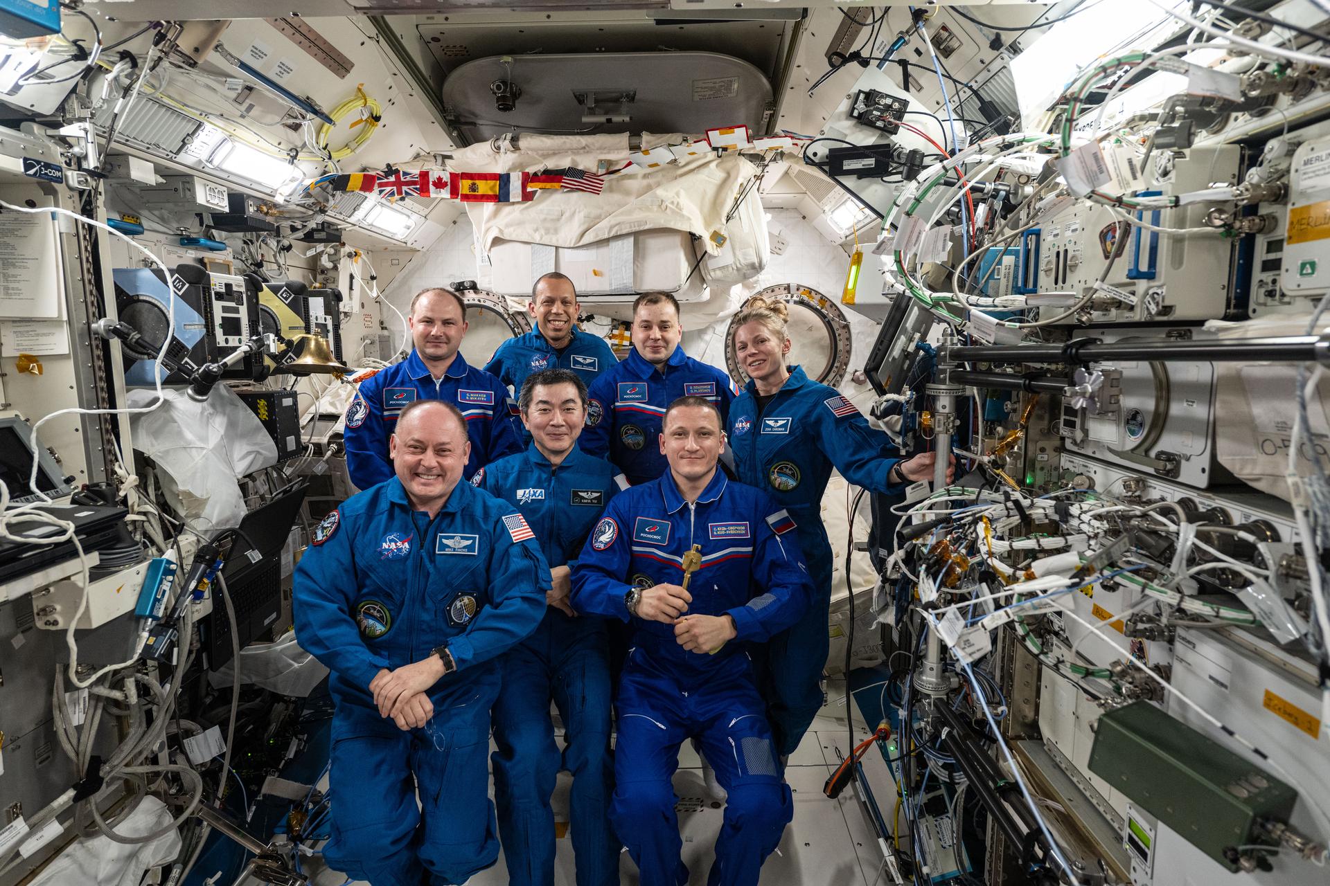 The seven-member Expedition 74 crew gathers for a crew portrait aboard the International Space Station's Kibo laboratory module. Moments earlier, NASA astronaut Mike Fincke (front left) handed over command of the orbital outpost to Roscosmos cosmonaut Sergey Kud-Sverchkov (front right) during a traditional Change of Command ceremony. Clockwise from center are, JAXA (Japan Aerospace Exploration Agency) astronaut Kimiya Yui, Roscosmos cosmonaut Sergei Mikaev, NASA astronaut Chris Williams, Roscosmos cosmonaut Oleg Platonov, and NASA astronaut Zena Cardman. Fincke returned to Earth with Cardman, Yui, and Platonov returned to Earth on Jan. 15 aboard the SpaceX Dragon crew spacecraft ending NASA's SpaceX Crew-11 mission to the orbital outpost.