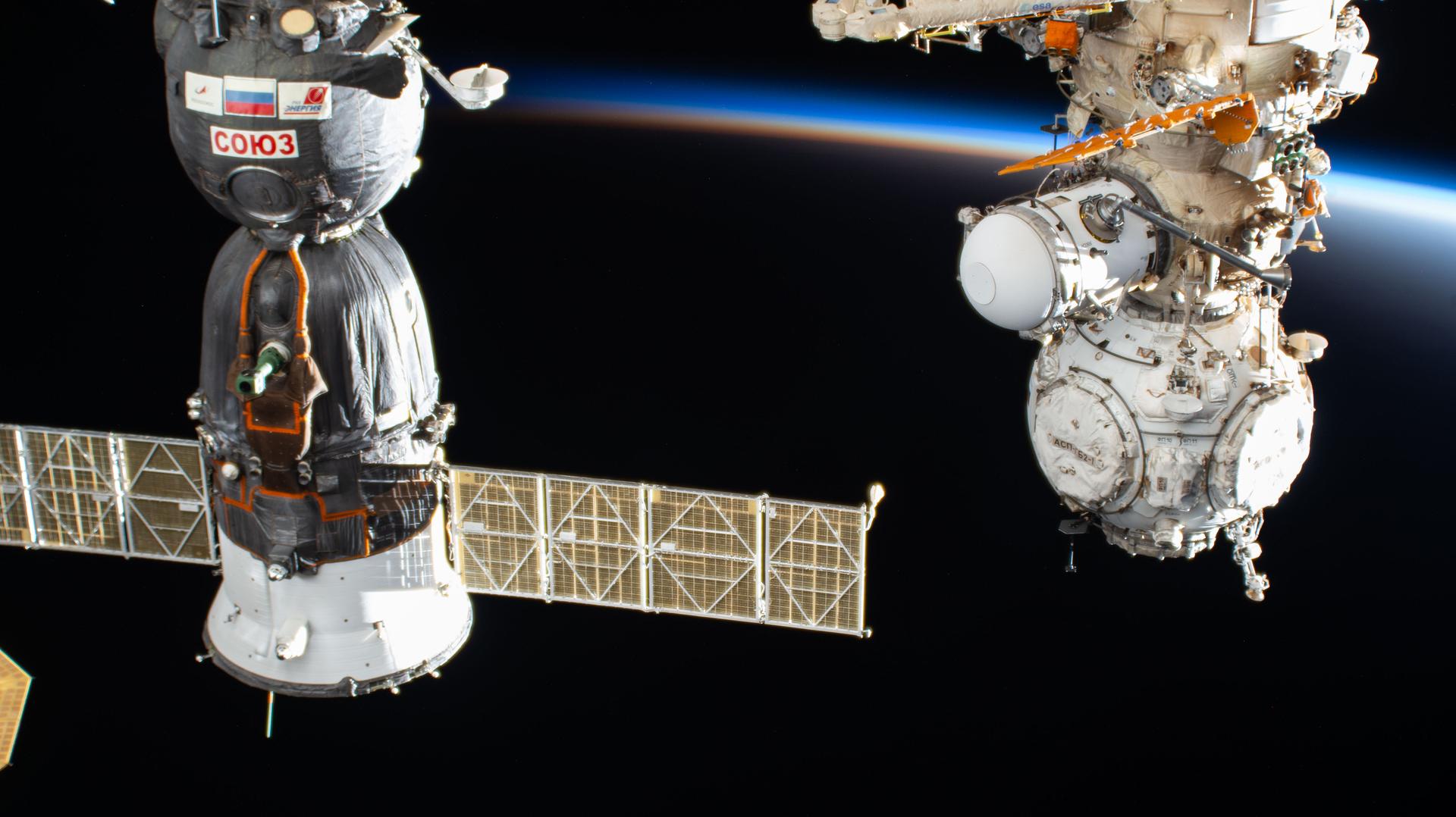 The International Space Station orbits into a sunset 260 miles above China near the Yellow Sea. In the foreground, are the Soyuz MS-28 crew spacecraft (left) and the Prichal docking module (right) attached to the Nauka science module.