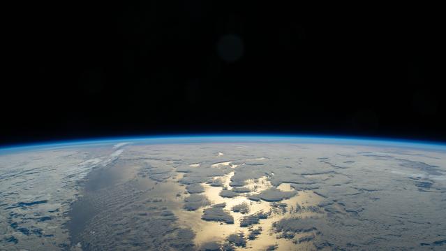 NASA image: Earth's thin blue atmosphere traces the planet's horizon above the Pacific Ocean