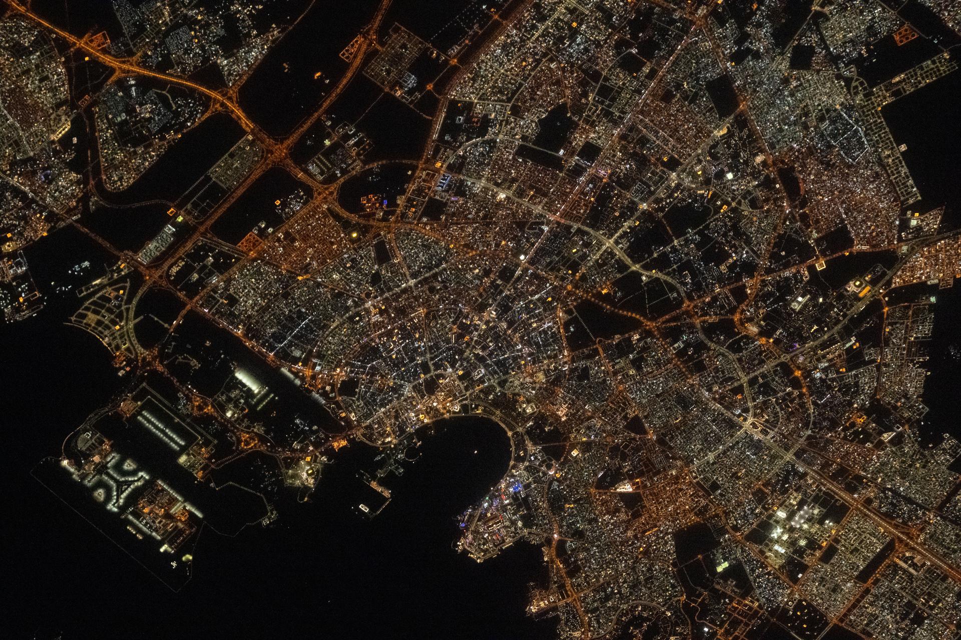 Doha, the capital and financial hub of Qatar with a population of about 2.4 million, is pictured at approximately 11:18 p.m. local time from the International Space Station as it orbited 262 miles above the Persian Gulf. At bottom left, is Hamad International Airport, featuring some of the longest runways in the world, built to accommodate next-generation aircraft such as the Airbus A380.