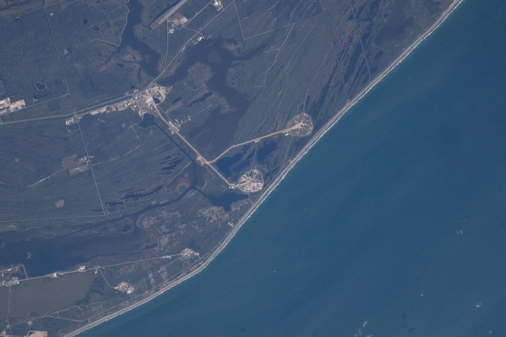 NASA's Kennedy Space Center in Florida is pictured from the International Space Station as it orbited 258 miles above the Sunshine State. NASA’s Space Launch System (SLS) rocket and Orion spacecraft can be seen on Launch Pad 39B (right center) with Launch Pad 39A just beneath it along the Atlantic coast. Artemis II will be the first crewed mission on NASA’s path to establishing a long-term presence at the Moon for science and exploration. The 10-day flight will help confirm systems and hardware needed for early human lunar exploration missions.