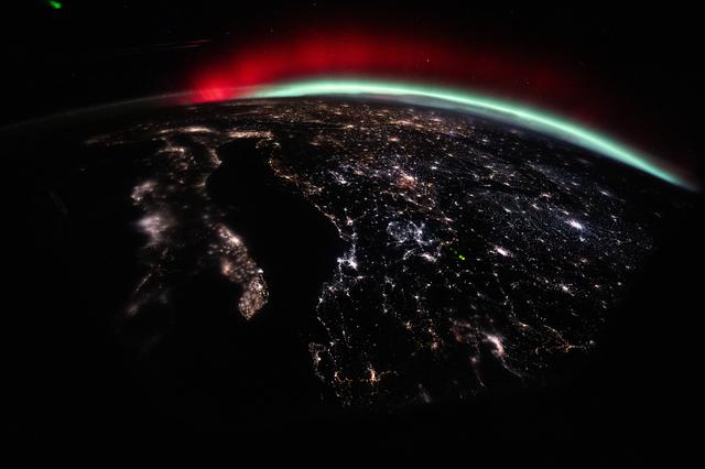 NASA image: A green and red aurora streams across Earth’s horizon above Europe