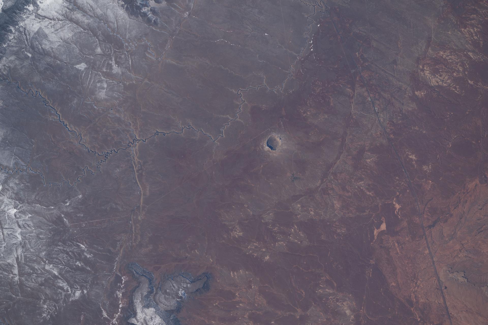 Meteor Crater in Arizona, a meteorite impact site approximately 4,000 feet in diameter and formed about 50,000 years ago in the high desert of the Colorado Plateau, is pictured from the International Space Station as it orbited 260 miles above the southwestern United States.