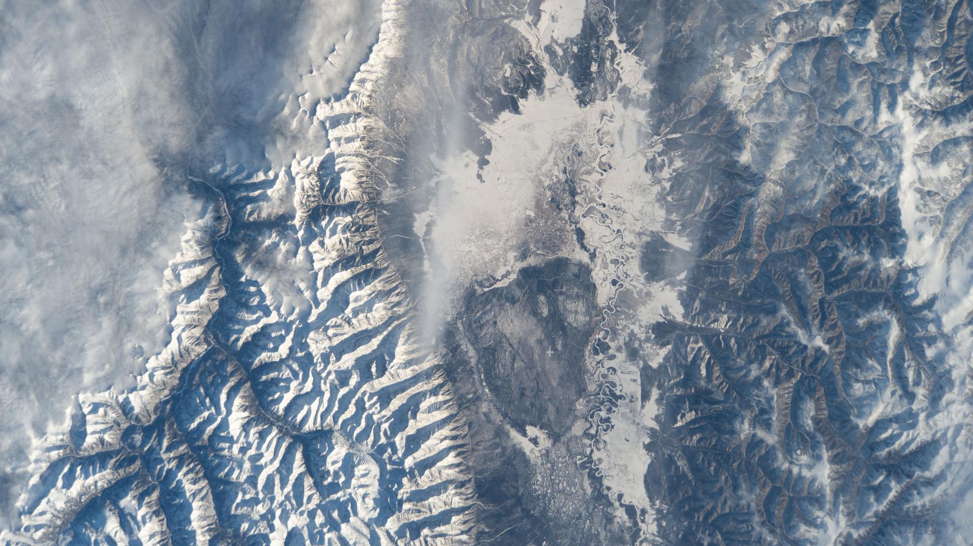 The frozen Irkut River runs through Tunkinskiy National Park in southern Siberia, forming the Tunka Valley, which is surrounded by mountains in this wintry, biodiverse landscape. The International Space Station was orbiting 262 miles above, between Lake Baikal and Lake Khövsgöl, when this photograph was taken.