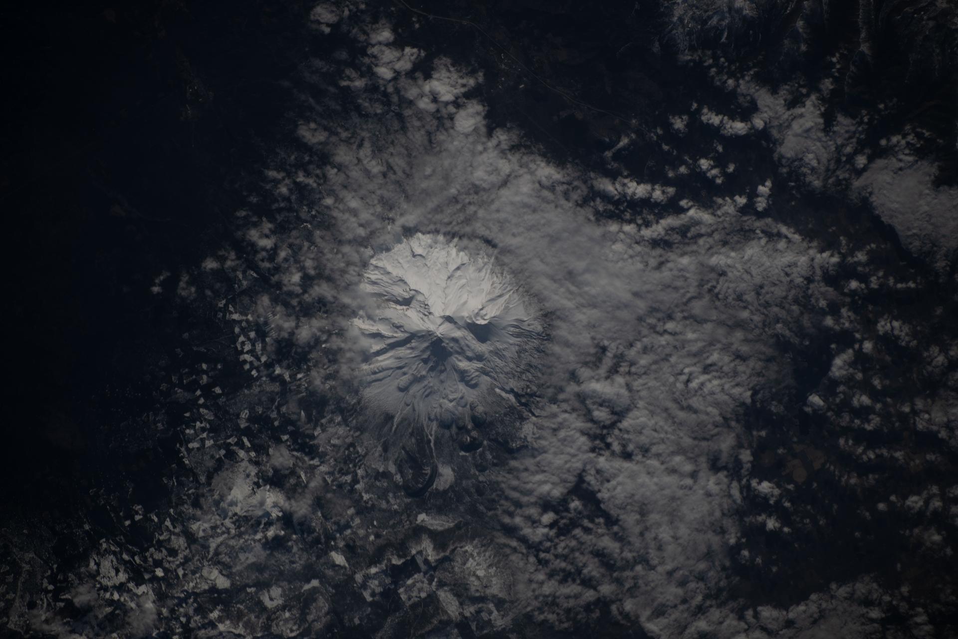 iss074e0312698 (Feb. 9, 2026) --- The snow-capped Mount Shasta is surrounded by clouds formed when warm air rises, cools, and condenses into moisture. The International Space Station was orbiting 260 miles above northern California when this photograph was taken. Credit: NASA/Chris Williams