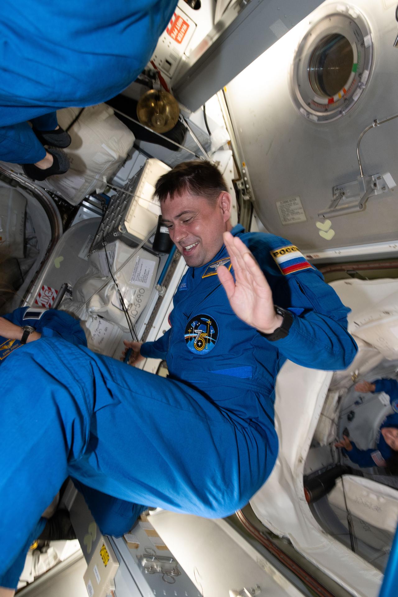 Roscosmos cosmonaut and SpaceX Crew-12 Mission Specialist Andrey Fedyaev enters the International Space Station after docking aboard the Dragon spacecraft to join Expedition 74 and begin a long-duration microgravity research mission.