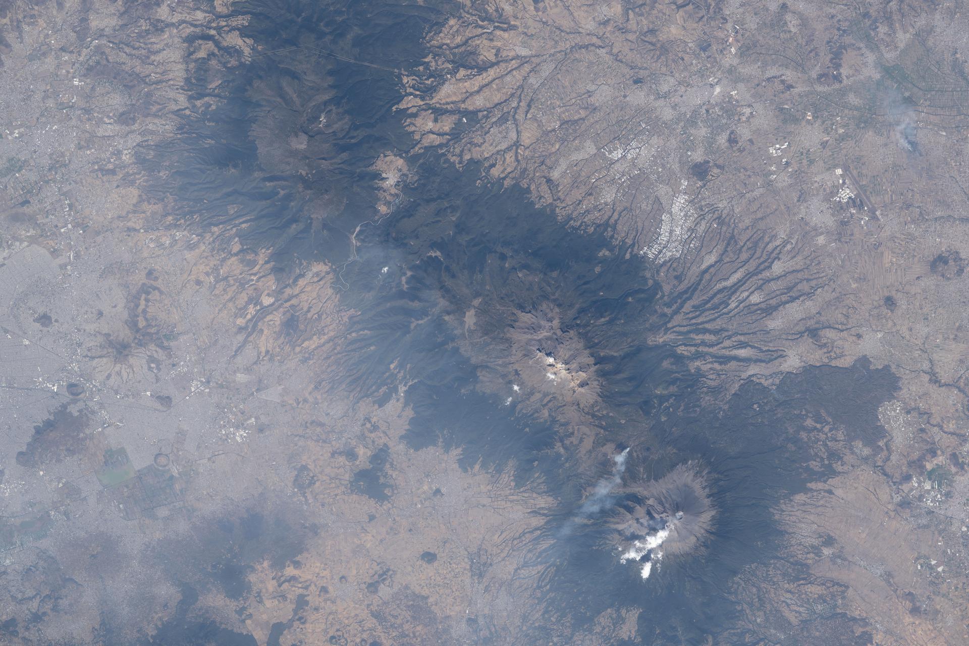 iss074e0315658 (Feb. 13, 2026) --- The three prominent mountaintops just east of Mexico City consist of two dormant volcanoes— Iztaccíhuatl and La Malinche— and one active volcano, Popocatépetl (bottom), the tallest peak among the three at 17,802 feet. The International Space Station was orbiting 259 miles above Mexico when this photograph was taken. Credit: NASA/Chris Williams