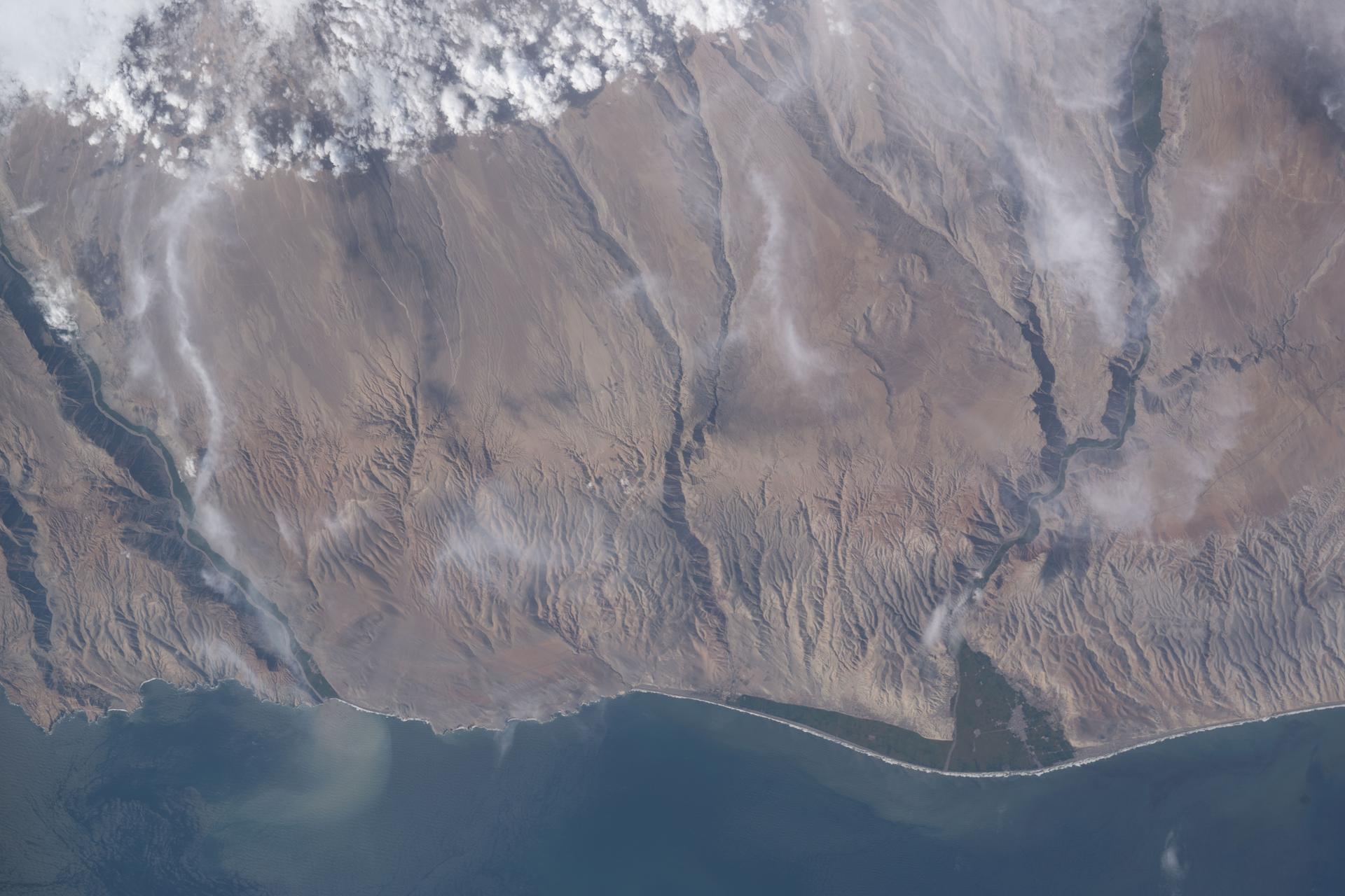 iss074e0315662 (Feb. 13, 2026) --- A portion of the Atacama Desert along Peru’s southern Pacific coast, featuring barren plains, rocky cliffs, vast sand dunes, and fertile river valleys, is pictured from the International Space Station as it orbited 265 miles above the South American nation. Credit: NASA/Chris Williams