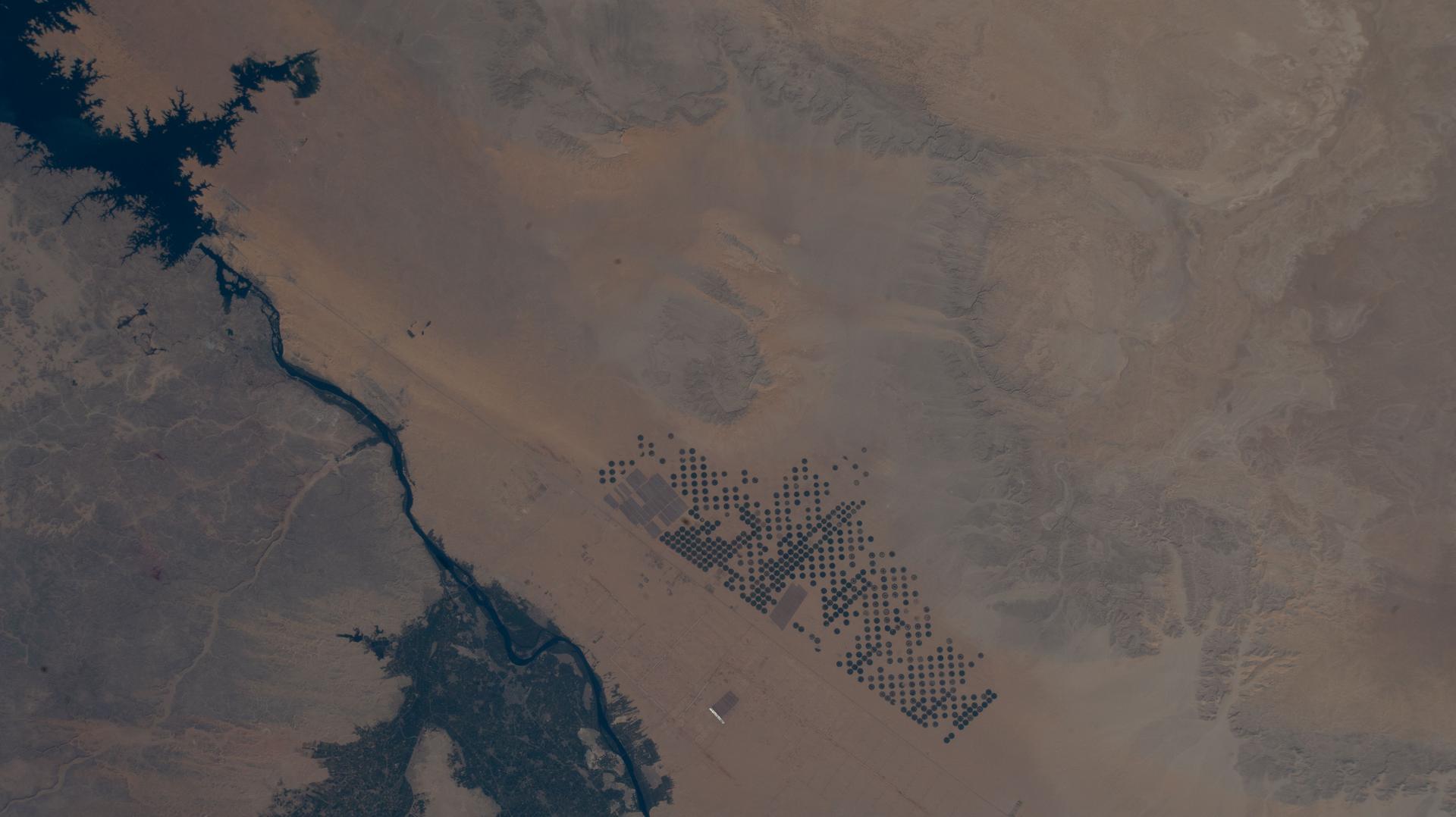 Egypt’s Nile River turns into Lake Nasser (upper left) at the Aswan High Dam, where the water spreads into a vast artificial reservoir that controls the river’s flow, prevents flooding, and generates hydroelectric power. Center‑pivot irrigation systems appear near the center bottom, forming perfect circles of crops such as potatoes and wheat. The International Space Station was orbiting 258 miles above the African nation at the time of this photograph.