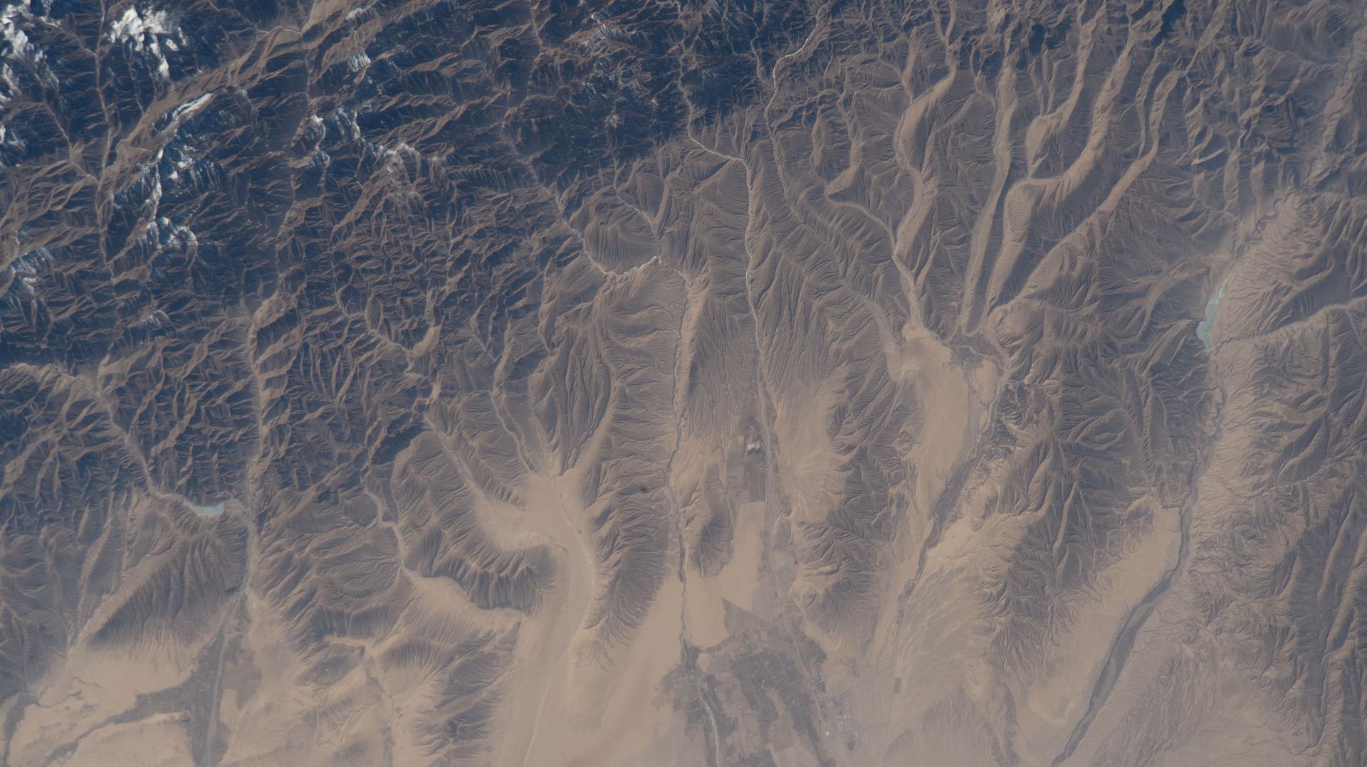 iss074e0316083 (Feb. 18, 2026) --- The far western edge of the Taklamakan Desert—the world’s second-largest shifting sand desert—meets the Pamir Mountains in China, where scorching desert conditions transition to frigid alpine terrain. The International Space Station was orbiting 259 miles above Central Asia when this photograph was taken.