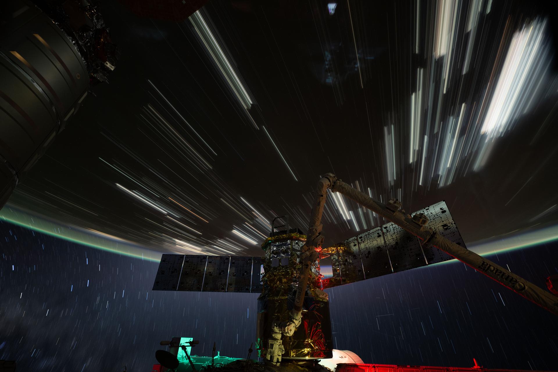 iss074e0319682 (Feb. 19, 2026) --- Star trails and city lights streak across this long-duration photograph taken from the International Space Station as it orbited 261 miles above the China–Mongolia border at approximately 4:42 a.m. local time. In the foreground is JAXA’s (Japan Aerospace Exploration Agency) HTV-X1 cargo craft, berthed to the Harmony module’s Earth-facing port, with the Canadarm2 robotic arm perched on a portable data grapple fixture in front. Credit: NASA/Chris Williams