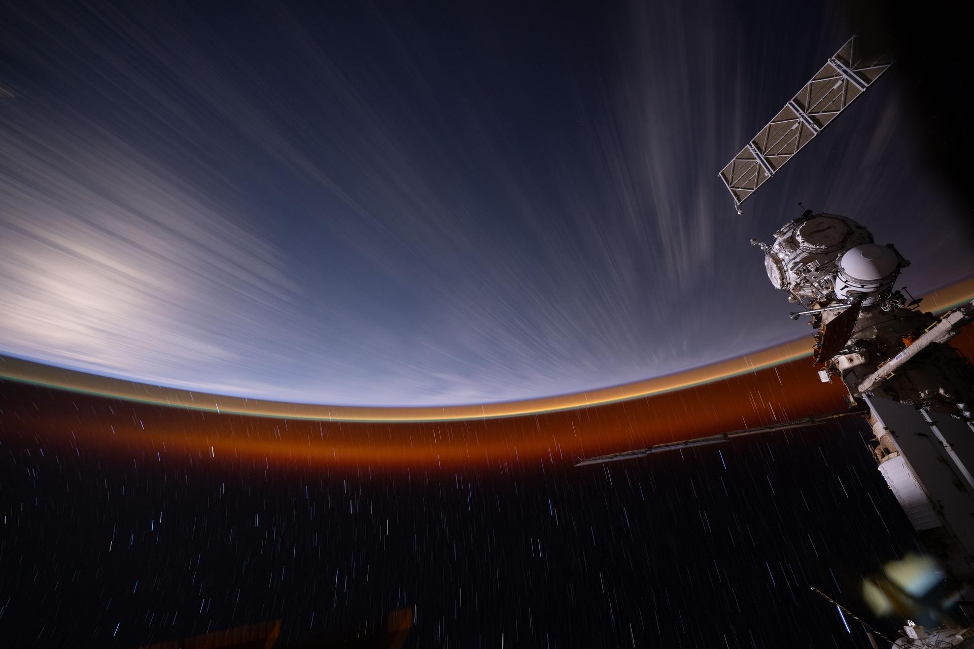 The International Space Station was soaring 263 miles above the Pacific Ocean near the island of Hawaii when this 30‑second long‑duration photograph was taken, revealing Earth’s atmospheric glow and star trails at approximately midnight local time.