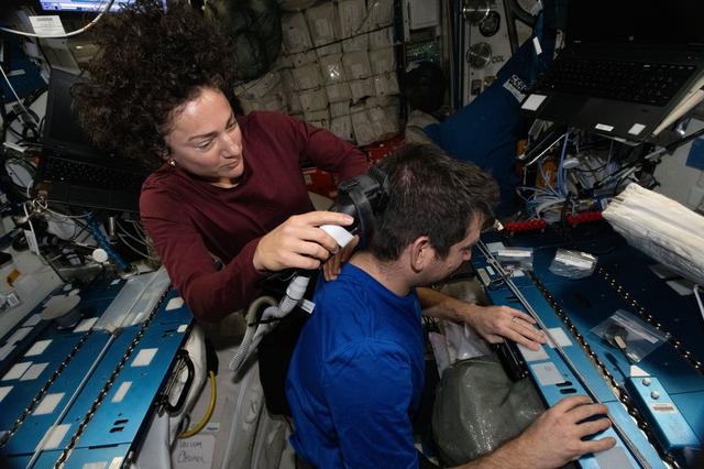 NASA image: NASA astronaut Jessica Meir trims the hair of fellow NASA astronaut Jack Hathaway