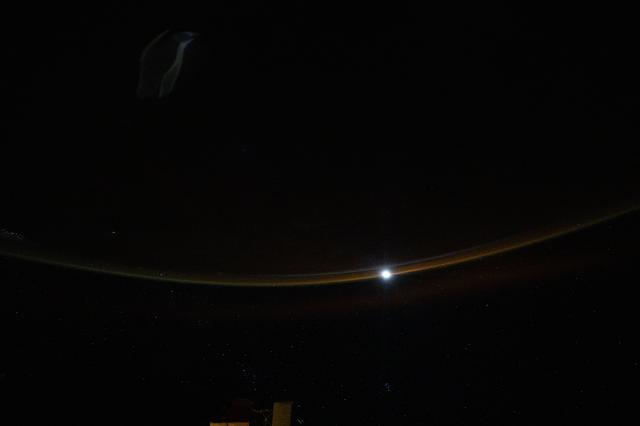 NASA image: A dim airglow blankets Earth’s horizon as a faint Moon sets above the Indian Ocean