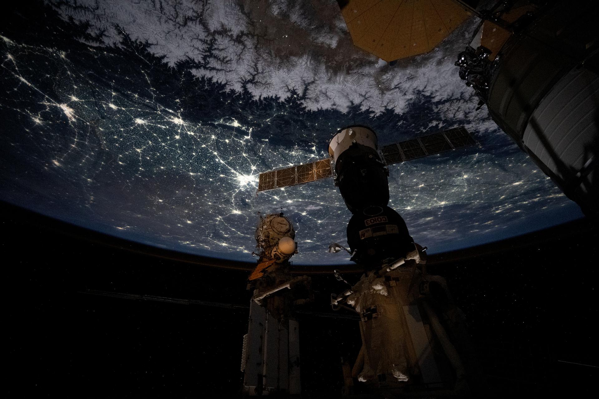 The snow‑capped Himalayas form a natural boundary between Asia and the well‑lit nighttime cityscape of the Indian subcontinent. At center is Delhi, the capital territory of India, with a metropolitan population of about 33.8 million. The International Space Station was orbiting 264 miles above southwestern China at approximately 11:22 p.m. local time when this photograph was taken.