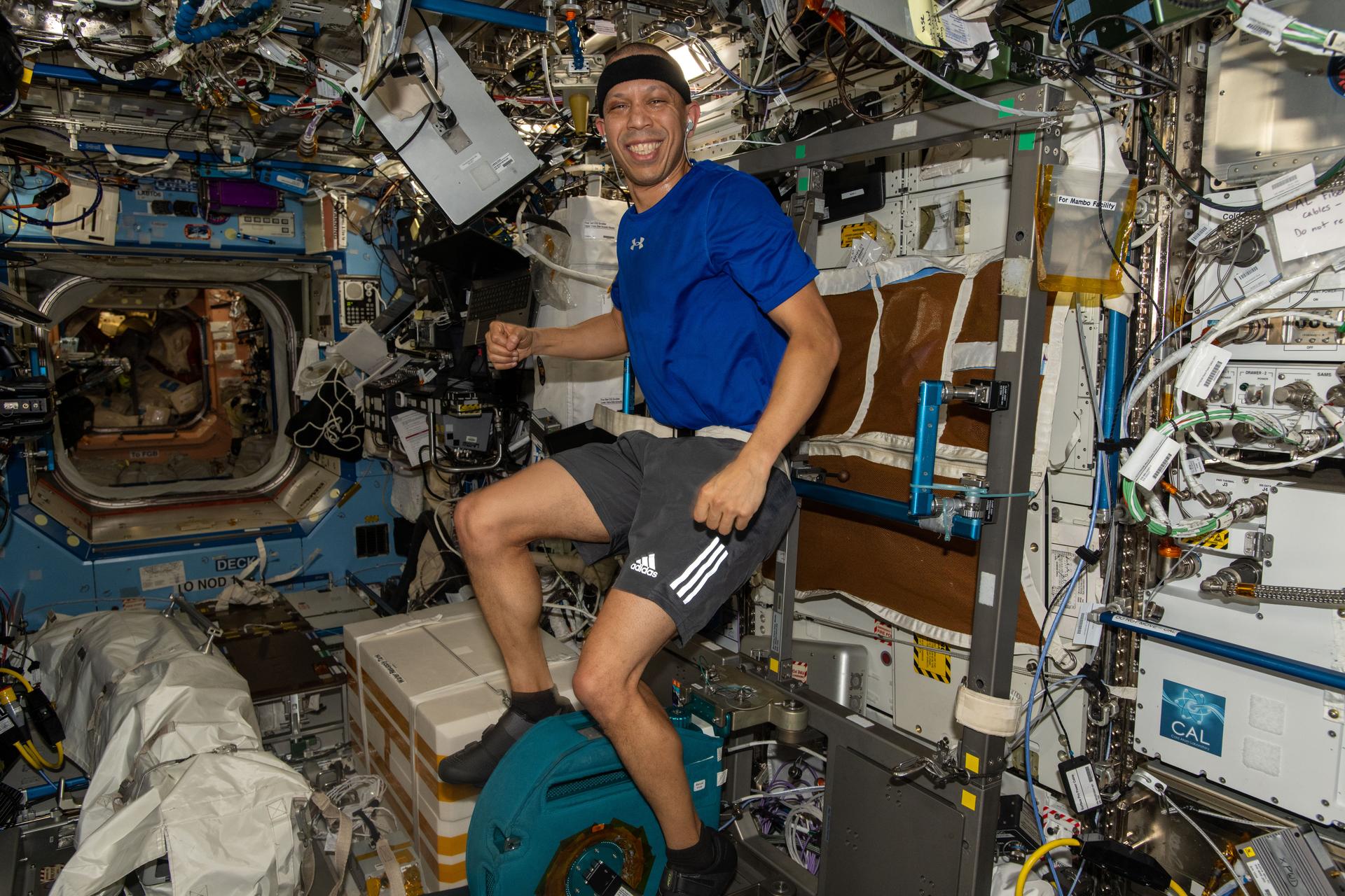 NASA astronaut and Expedition 74 flight engineer Chris Williams pedals on the exercise cycle inside the International Space Station’s Destiny laboratory module. Astronauts work out daily on the exercise cycle to maintain muscle, bone, and cardiovascular health in microgravity.
