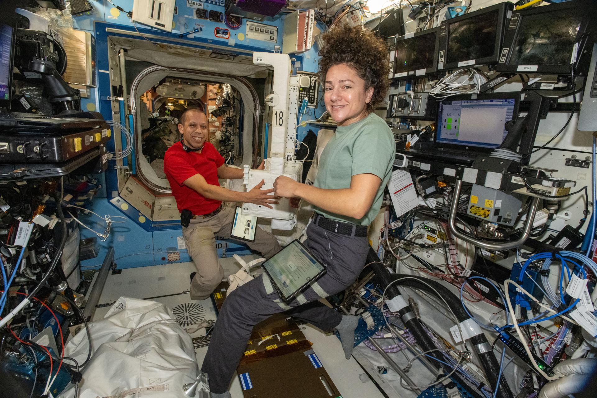 NASA astronauts Chris Williams and Jessica Meir, both Expedition 74 flight engineers, inspect and configure a spacesuit jetpack, known as the Simplified Aid for EVA Rescue (SAFER), inside the International Space Station’s Destiny laboratory module. The jetpacks attach to the rear of spacesuits and serve as a safety mechanism that allows a spacewalker to maneuver back to the station in the unlikely event they become untethered from their worksite.