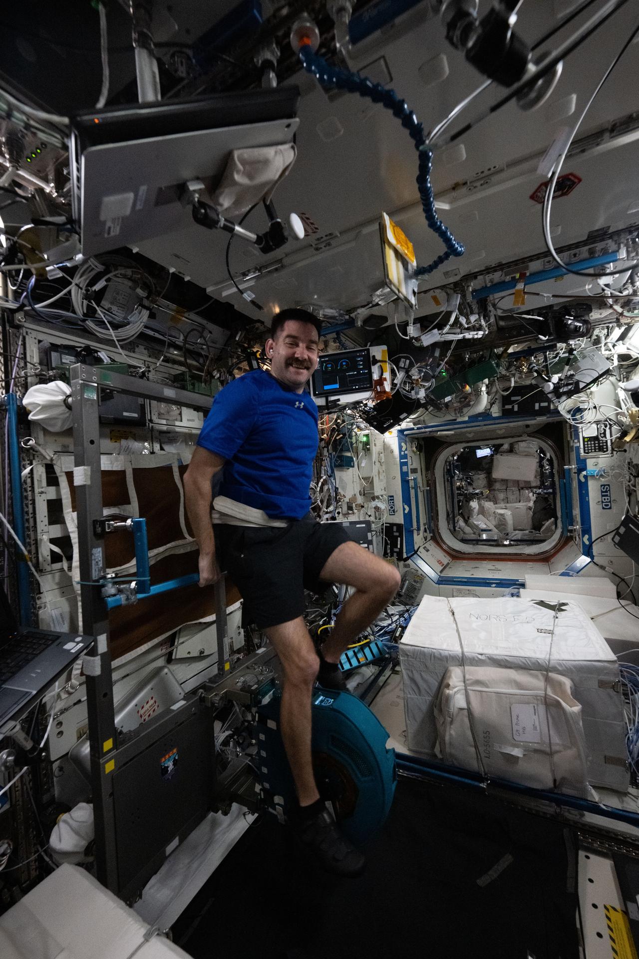NASA astronaut Jack Hathaway pedals on an exercise cycle