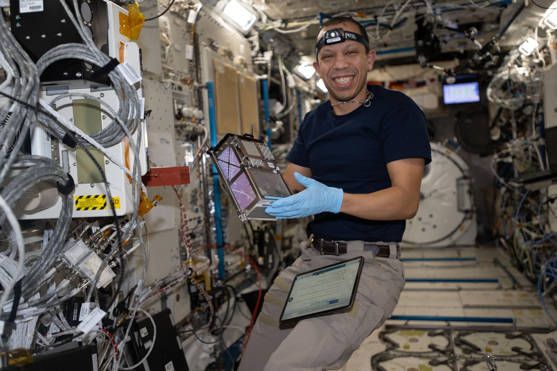NASA astronaut and Expedition 74 flight engineer Chris Williams shows off biology research hardware inside the International Space Station's Kibo laboratory module. The scientific gear supports an investigation that explores using a bioregenerative life-support resource to produce oxygen, regenerate air and water, and provide nutritional supplements on spacecraft during long-term missions farther away from Earth.