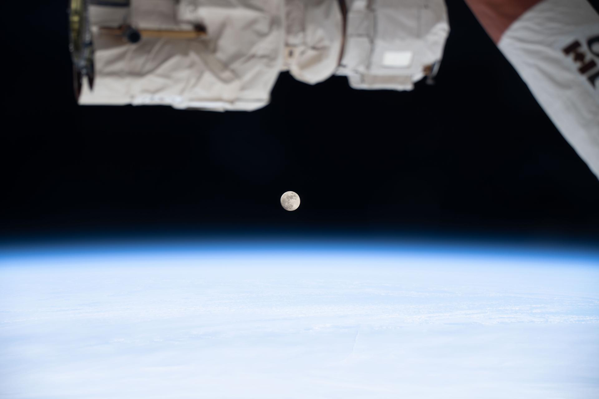 A waxing gibbous Moon is pictured above Earth's atmosphere from the International Space Station as it soared 268 miles above far eastern Canada. A portion of the Canadarm2 robotic arm's latching end effector is captured in the top foreground of the image.