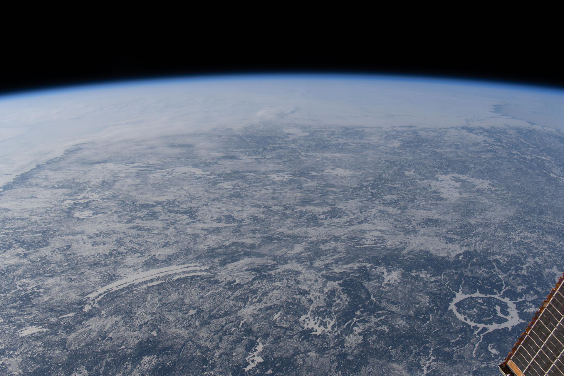 Canada’s icy landscape is pictured from the International Space Station as it orbited 266 miles above North America. At bottom right, is the Manicouagan Crater in Quebec, formed about 214 million years ago by a massive meteorite impact and one of the largest craters on Earth. It is surrounded by a ring‑shaped lake called the Manicouagan Reservoir and is part of a major hydroelectric system that contributes significantly to Quebec’s energy supply.